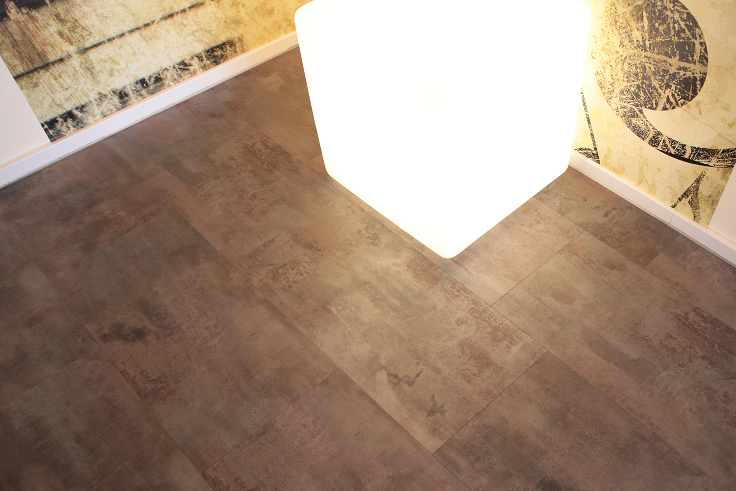 Designboden in moderner Betonoptik mit weißer Sockelleiste und strukturierter Wandgestaltung – präzise Bodenverlegung vom Malerfachbetrieb Binder