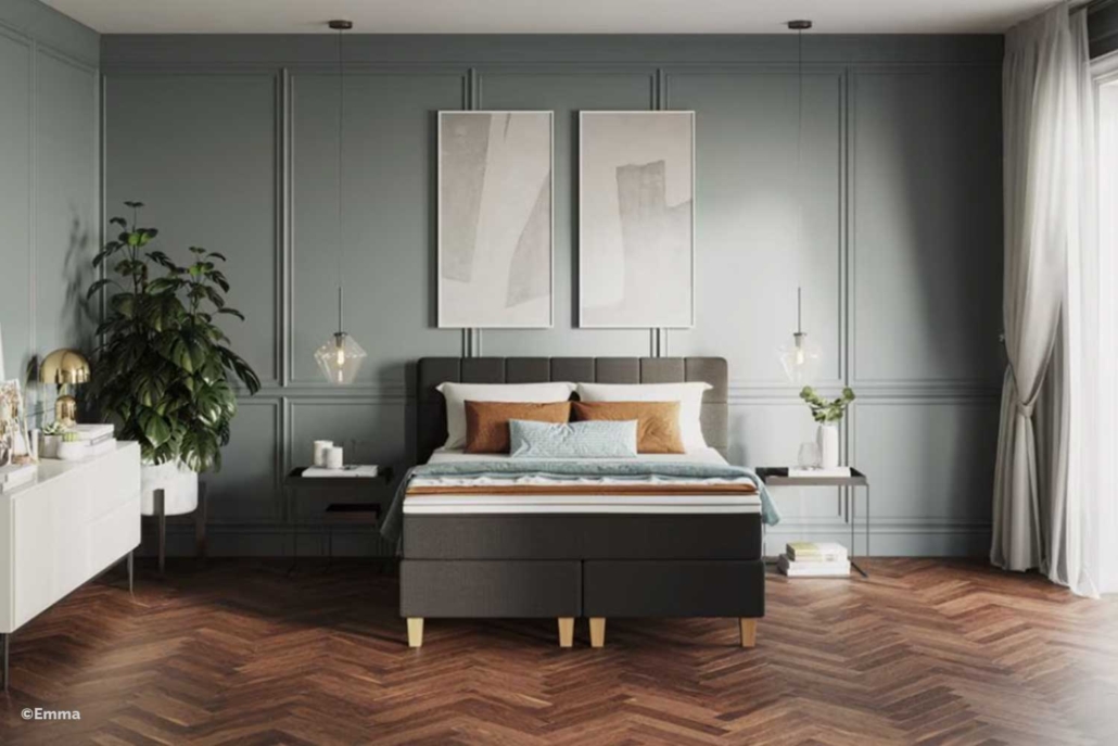 Schlafzimmer mit glatt verarbeiteten graublauen Wänden, dekorativen Wandpaneelen und dunklem Fischgrätparkett – hochwertige Raumgestaltung vom Malerfachbetrieb Binder