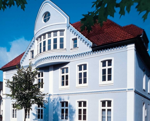 Altbaufassade in hellblauer Caparol-Farbe mit weiß abgesetzten Fenstern – renoviert vom Malerfachbetrieb