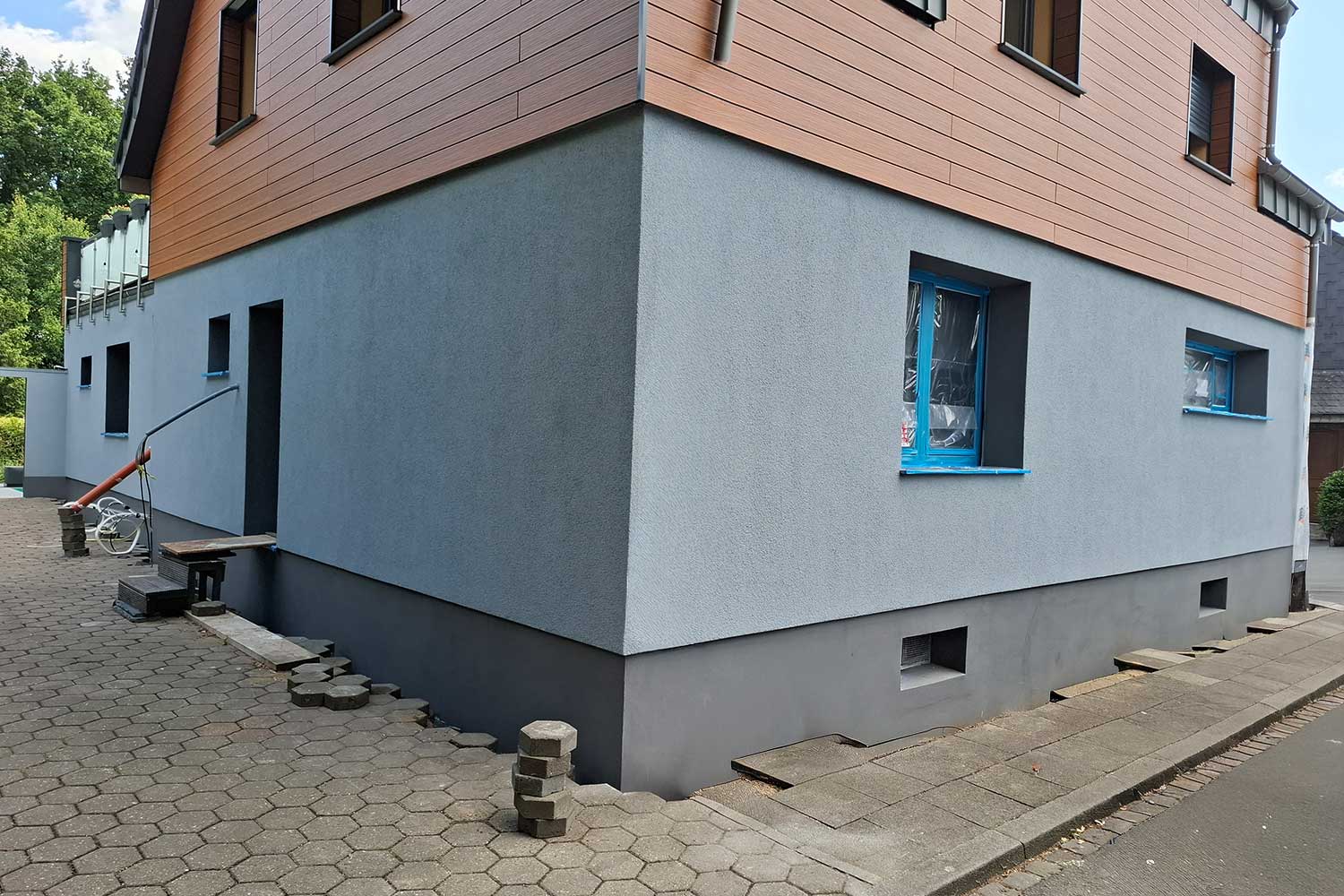 Wärmedämmverbundsystem (WDVS) mit hellgrauer Putzfassade und dunklem Sockel – energetische Fassadensanierung durch Malerfachbetrieb Binder